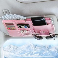 a pink purse filled with money and sunglasses