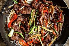 beef stir fry with peppers and onions in a skillet