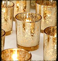 gold colored candles are lined up on a table