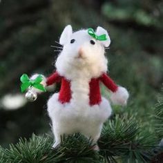 a white mouse ornament hanging from a christmas tree