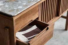 a close up of a wooden table with drawers and a towel on it's side