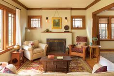 a living room filled with furniture and bookshelves next to a fire place in a wooden paneled wall