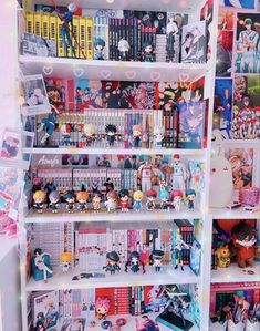 a book shelf filled with lots of books and anime figurines on top of it