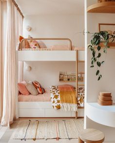 a bedroom with bunk beds and plants on the wall, in front of a window