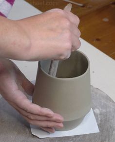 a person is making a vase out of clay