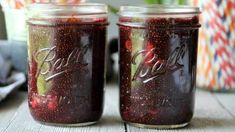 two jars filled with fruit sitting on top of a table