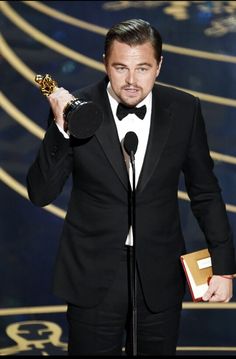 the actor is holding an award in his hand