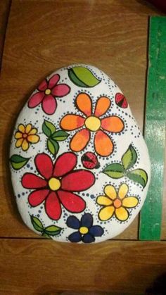 a painted rock sitting on top of a wooden table