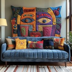 a blue couch with colorful pillows on it in front of a large wall art piece