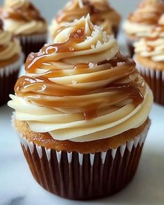 some cupcakes with frosting and caramel on top