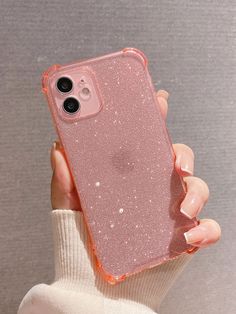 a person holding an iphone case in their hand with pink glitter on the phone cover