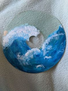 a blue and white painting on a glass disc