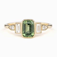 * One of a kind ring * In stock ready to ship in size 7 * 1.43ct Emerald Cut Madagascar Sapphire Light Green 7.09x5.06x3.61mm Unheated * Center stone clarity: vs1-some inclusion visible under x10 loupe and slightly visible on close eye inspection but does not affect the brilliance of the stone. * Bandwidth: approx. 1.5mm * 0.33ctw natural accent diamonds * Low profile bezel setting * Ethically sourced solid 14k yellow gold and gemstones * Packaged in a velvet ring box Emerald Cut Sapphire Ring, Montana Sapphire Ring, Green Sapphire Engagement, Green Sapphire Engagement Ring, The Bling Ring, Green Sapphire Ring, Ring Emerald Cut, Future Engagement Rings, Emerald Cut Engagement