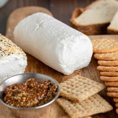 bread, crackers and cheese are on a cutting board