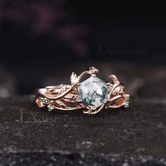 a close up view of a ring with an aqua stone in the center and leaves on it