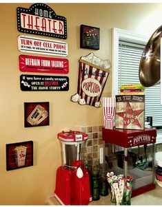 a popcorn machine sitting on top of a kitchen counter next to a wall mounted movie signs