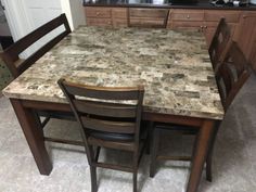 a kitchen table with two chairs next to it