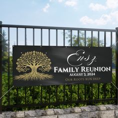 a black and gold family reunion sign in front of a fenced area with trees