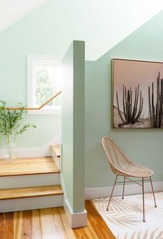 a chair sitting on top of a hard wood floor next to a wall mounted plant