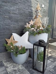 two cement planters with plants in them and a lantern on the ground next to it