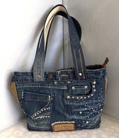 a handbag made out of jeans with studded details on the front and sides