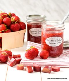 strawberry jam in a jar with strawberries and rhubars on the side