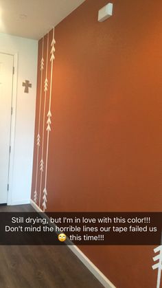 an orange wall with white arrows painted on it and the words still driving, but i'm in love with this color