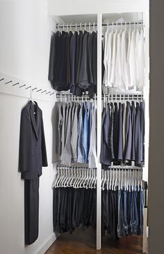 an organized closet with clothes hanging on racks