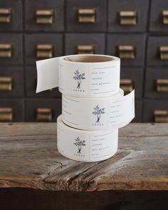 three rolls of white washi tape sitting on top of a wooden table next to drawers