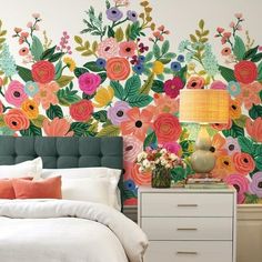 a bedroom with colorful flowers painted on the wall