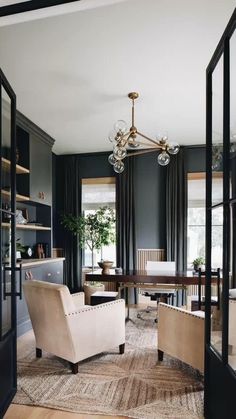 a living room filled with furniture and a chandelier hanging over the top of it