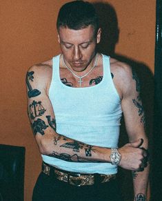 a man with tattoos on his arms and armbands looking down at the camera