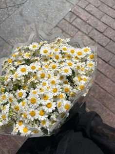 a bouquet of daisies on the back of a motorcycle