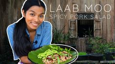 a woman holding a plate full of food with the caption lab moo spicy pork salad