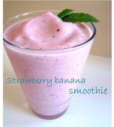 a smoothie in a tall glass with a green leaf on the top and strawberry banana smoothie