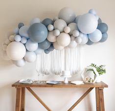 a table topped with balloons and vases on top of it next to a wall