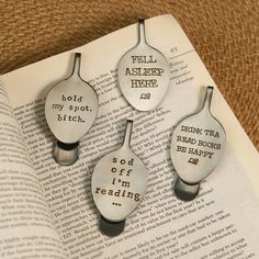 three spoons that are sitting on top of an open book with words written on them