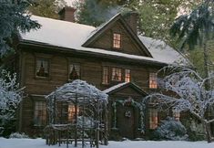 an old house is covered in snow and surrounded by trees with the words little women on it