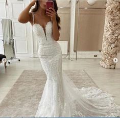 a woman is taking a selfie in her wedding dress while standing on the floor