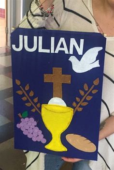 a woman holding up a sign with the word julian on it and a cross