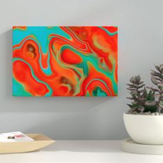 an abstract painting on the wall next to a potted plant