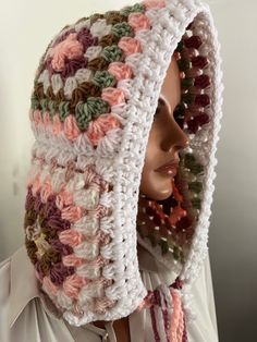 a mannequin wearing a crocheted hat with flowers on it's side