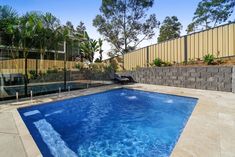 an empty swimming pool in the middle of a backyard with a fenced in area