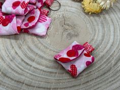 several small pieces of fabric sitting on top of a metal tray with flowers in the background