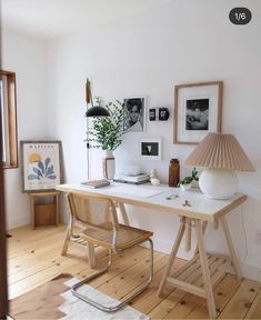 a desk with a lamp and pictures on the wall