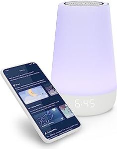 an alarm clock and phone next to it on a white surface with the time displayed