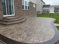 an outdoor patio with steps and grass in the background