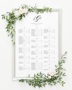 an elegant wedding seating chart with flowers and greenery on the side, in white frame