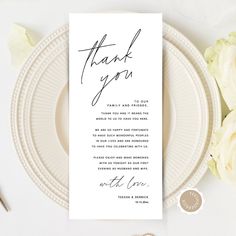 a thank you card on top of a plate next to some flowers and utensils