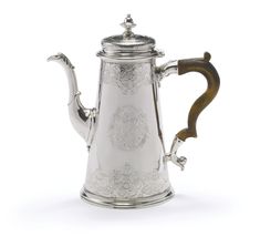 a silver coffee pot with wooden handles and an ornate design on the top, sitting against a white background